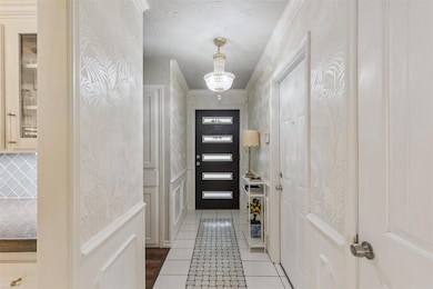 Doorway to outside featuring tile patterned flooring and a chandelier