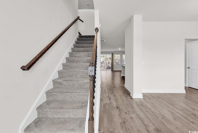 Stairs featuring wood finished floors and baseboards