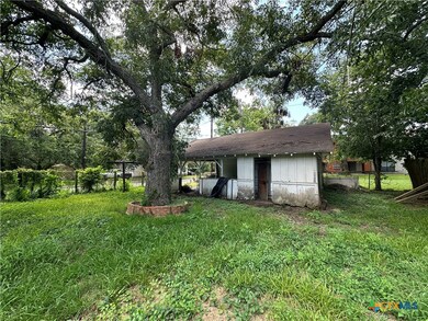 Large shaded backyard with mature trees.