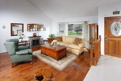 The living room is enriched by soaring ceilings, a striking bay window with elegant plantation shutters and complementary hardwood floors.