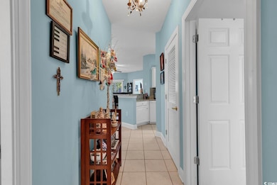 Corridor featuring a notable chandelier and light 