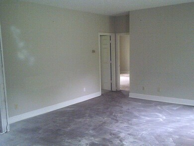 Spare room featuring concrete flooring and baseboards