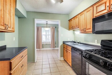 Kitchen features custom maple cabinetry and tile f