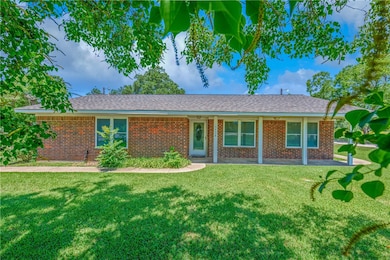 Ranch-style house with a front lawn and brick sidi