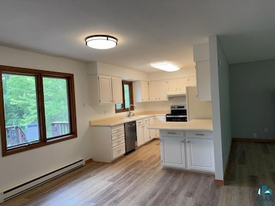 Kitchen with stainless steel electric range, a baseboard radiator, dishwasher, and healthy amount of natural light
