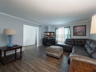 Living room with crown molding and dark hardwood /