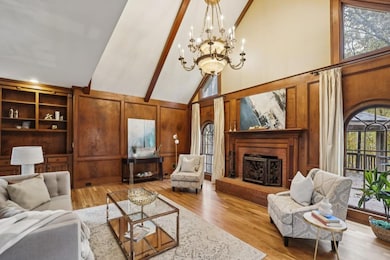At the heart of the home, the Fireside Family Room is a true showstopper, featuring a Vaulted, Beamed Ceiling, Custom Built-Ins, and Rich Wood-Paneled Walls, creating an atmosphere of warmth and elegance.