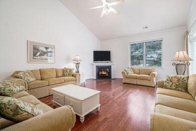 Living area featuring crown molding, healthy amount of natural light, dark wood-style flooring, a ceiling fan, and high vaulted ceiling