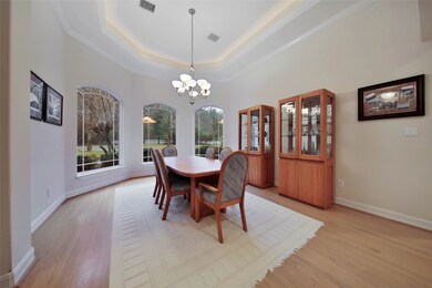 Formal dining area features tiered ceilings, natural stained hardwood flooring, plenty of natural light and room for plenty of furniture and storage options.