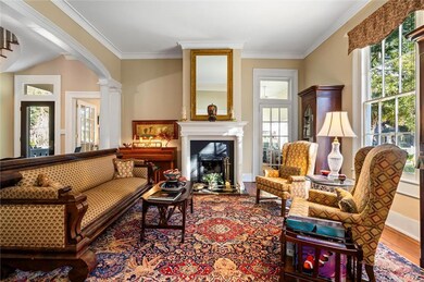 Living Room featuring plenty of natural light, a fireplace with wooden ornate columns, hardwood floors, and ornamental molding.