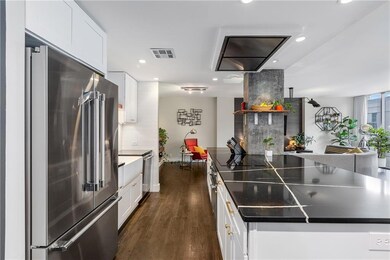 Kitchen featuring appliances with stainless steel finishes, recessed lighting, white cabinetry, dark wood-style flooring, and dark countertops