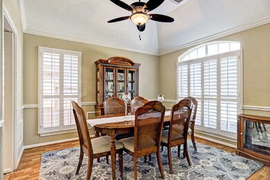 Dining room features updated fan with light, crown molding, chair rail and plantation shutters.