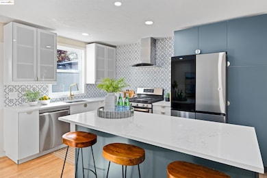 Kitchen featuring appliances with stainless steel finishes, backsplash, a breakfast bar, light stone counters, and recessed lighting