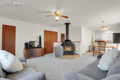Living room with new paint, wood stove, ceiling fan, carpet floors