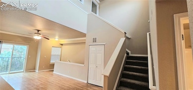 Staircase with wood finished floors, a ceiling fan, crown molding, and baseboards
