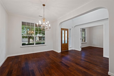 Foyer with arched walkways, dark wood-style floor