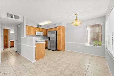Kitchen featuring white appliances, light countert