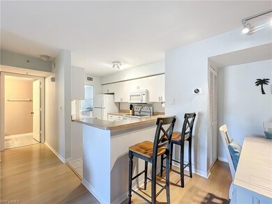 Kitchen with white appliances, light hardwood / wo
