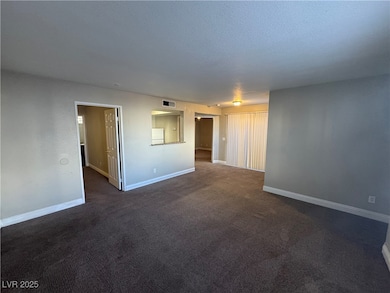 Unfurnished room featuring baseboards, a textured