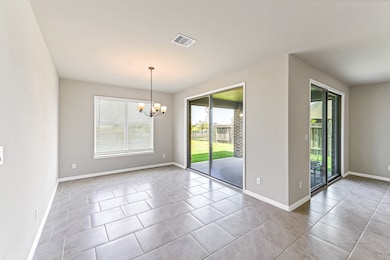 Dining area is oversized for accommodating large gatherings.  Notice the upgraded chandelier and the abundance of views to the backyard overlooking lake and fountain.  Definitely a vacation feel.