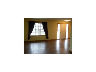Living Room. Rich, wood-like laminate flooring mak