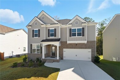 Craftsman house with board and batten siding, brick siding, a front lawn, concrete driveway, and a porch