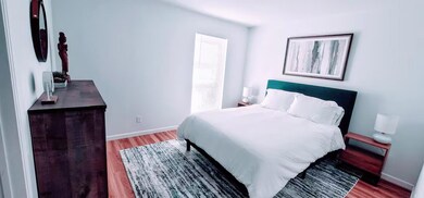 Bedroom with wood finished floors and baseboards