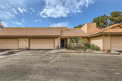 View of property with a tiled roof, driveway, and