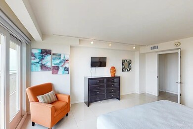 Bedroom featuring track lighting, light tile floors, and multiple windows