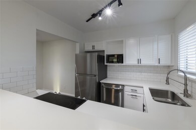 Kitchen with white cabinets, decorative backsplash