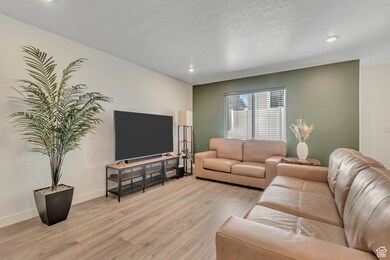 Living room with light wood-style floors and recessed lighting