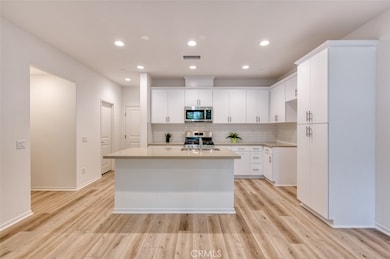 Kitchen with breakfast bar island, quartz counters, white subway tile backsplash and custom cabinetry.