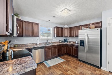 Kitchen featuring a textured ceiling, dark hardwoo