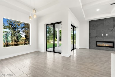 Unfurnished living room featuring a tray ceiling,