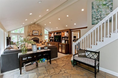 The floor to ceiling limestone fireplace is warm a