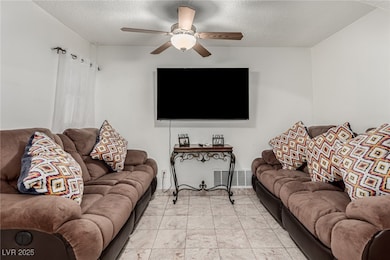 Living area featuring visible vents, a textured ce