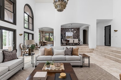 Living room with arched walkways, a chandelier, a