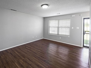 Empty room with visible vents, wood finished floor