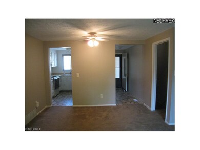 View from living room into kitchen and foyer. Door