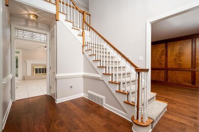 Staircase featuring wood finished floors, baseboards, a ceiling fan, and a tile fireplace