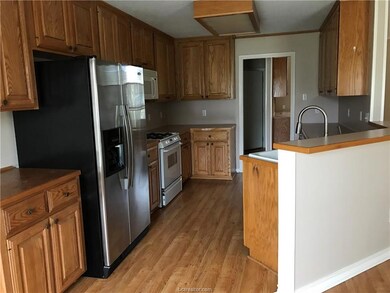 Kitchen featuring white appliances, light wood-typ