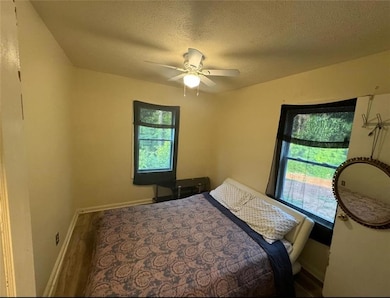 Bedroom featuring a textured ceiling, hardwood / w