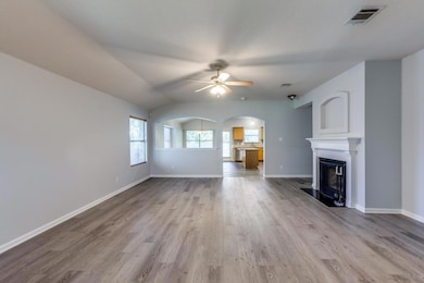 Unfurnished living room featuring ceiling fan, wo
