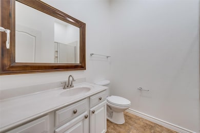 Bathroom with toilet, baseboards, and vanity