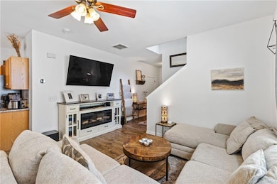 Living area with wood finished floors and a ceiling fan