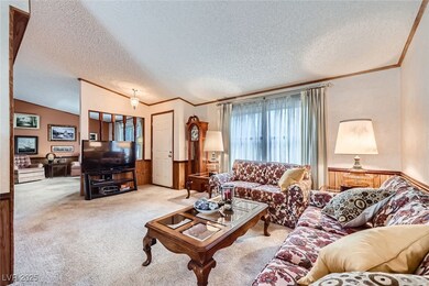 Carpeted living area featuring crown molding and a