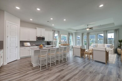 The kitchen is bathed in natural light, thanks to well-placed windows that infuse the space with a warm, inviting ambiance. It boasts a convenient island and a stylish breakfast bar, making it an ideal hub for culinary creativity and casual dining.