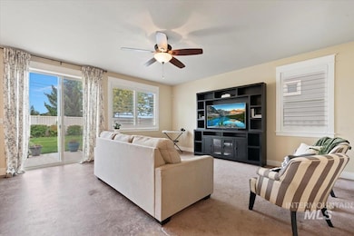 Living room with a ceiling fan and baseboards