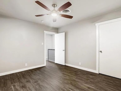 Unfurnished bedroom featuring dark wood finished floors and a ceiling fan