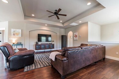 Living room with wood-type flooring, baseboards, 